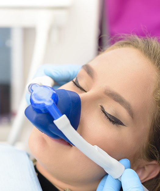 Woman resting with nitrous oxide sedation dentistry mask in place
