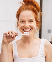 Woman brushing teeth in Pewaukee