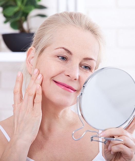 Older woman looking at flawless skin after Botox treatment