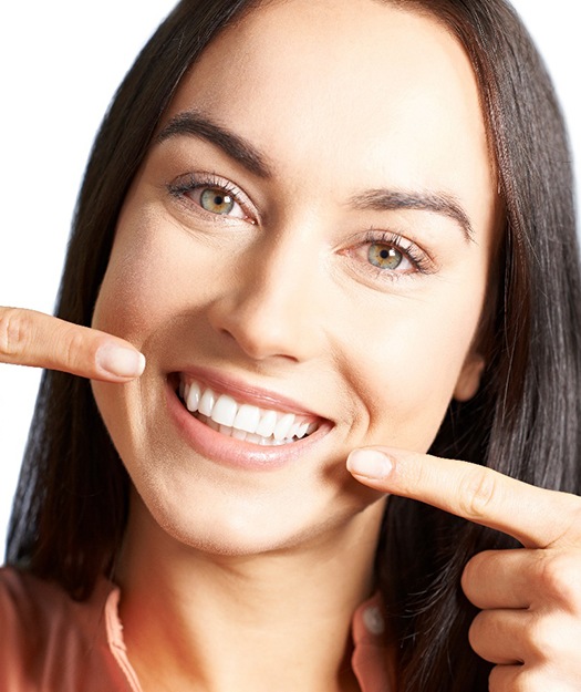 Woman pointing to healthy teeth and gums.