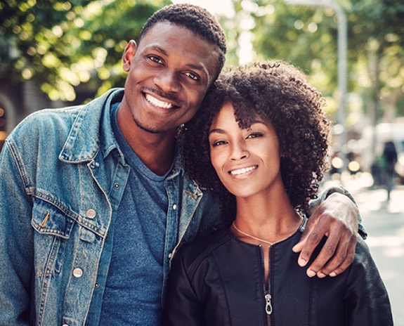 A man and woman smile after using their dental insurance in Pewaukee to maintain their teeth and gums