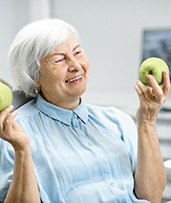 Woman holding apples with dental implants in Pewaukee