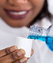 Closeup of woman with dental implants in Pewaukee pouting mouthwash