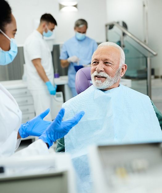 happy man talking to dentist about dental implants in Pewaukee 