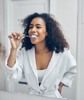 Woman brushing teeth in Pewaukee