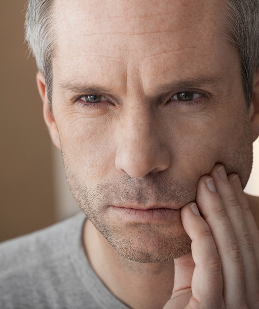 Man holding cheek before root canal therapy