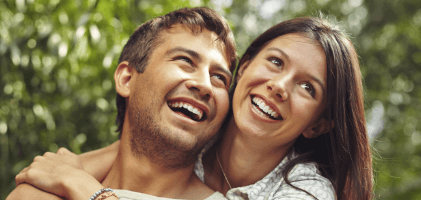 Man and woman sharing healthy smiles after periodontal therapy